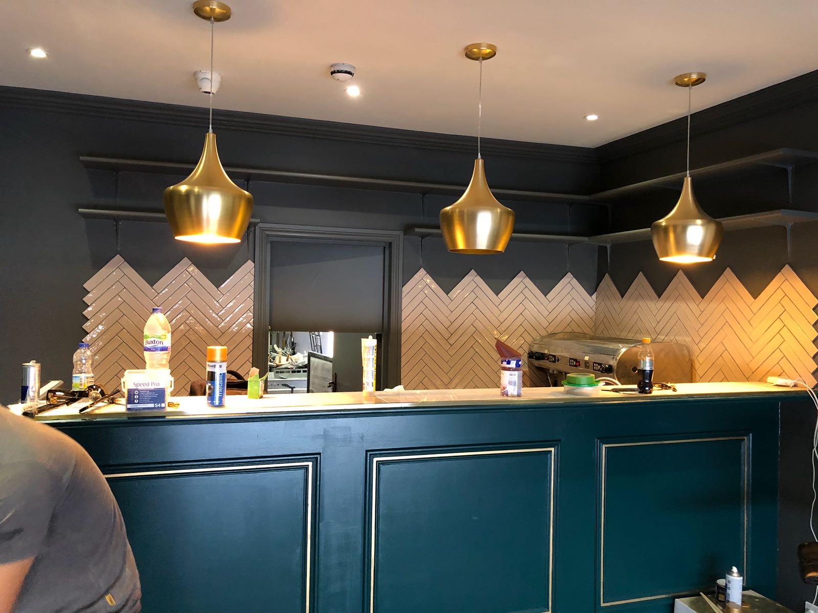 Restaurant bar with blue tiles and brass pendants